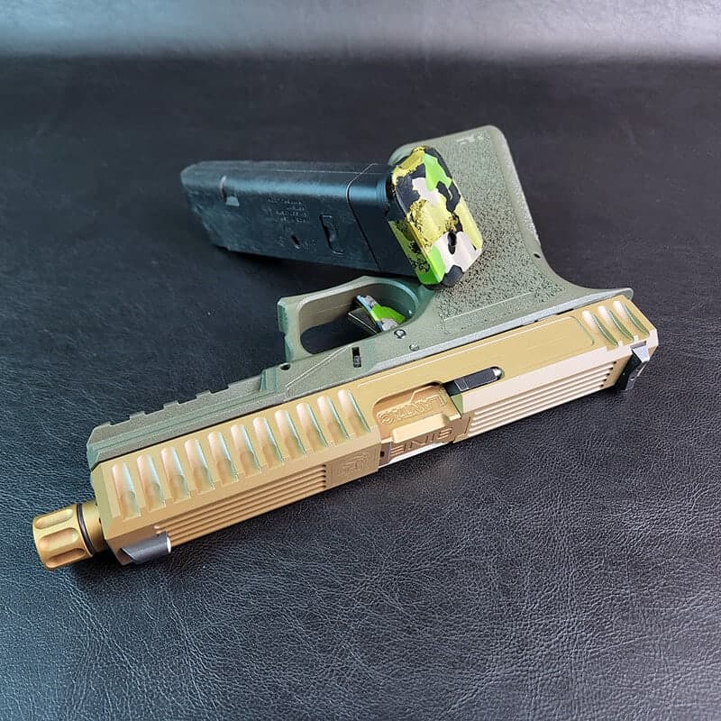 Bulldog slide in polished gold with angled serrations and a gold threaded barrel, on a dark Glock 17 frame