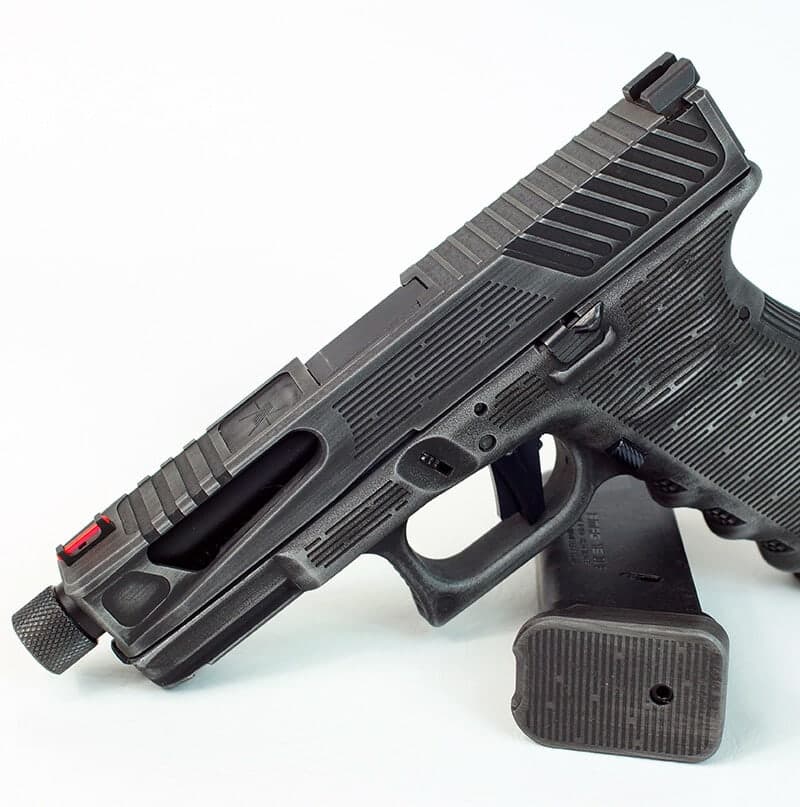 NMF slide in graphite black with stepped front and rear serrations, on a black Glock 19 frame against white