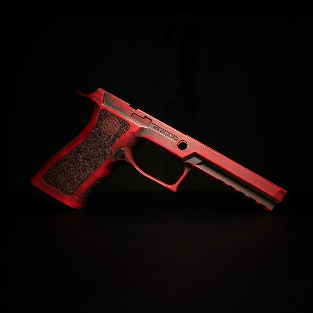 Sig P320 grip module refinished in bright red Cerakote, on a black background