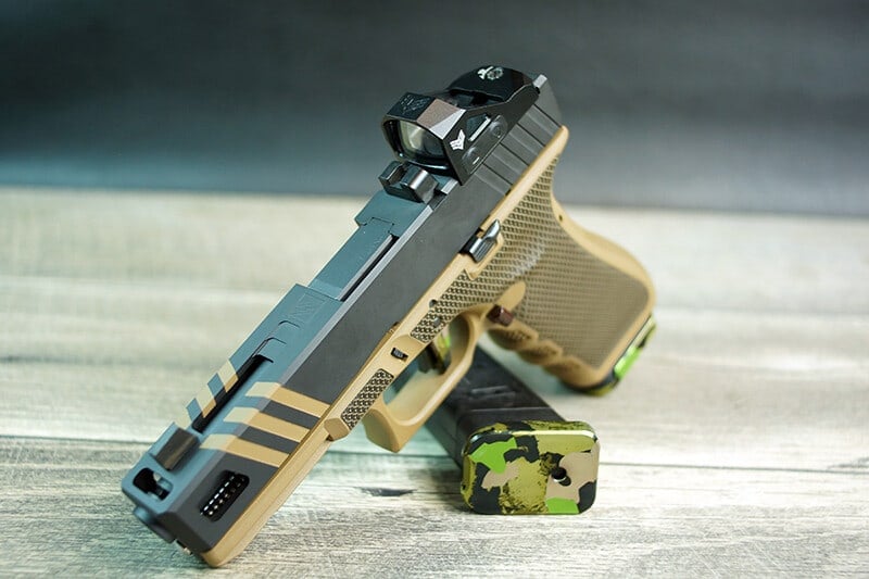 Apprentice slide in sniper grey with FDE stripes and a red dot optic, on an FDE Glock 17 frame