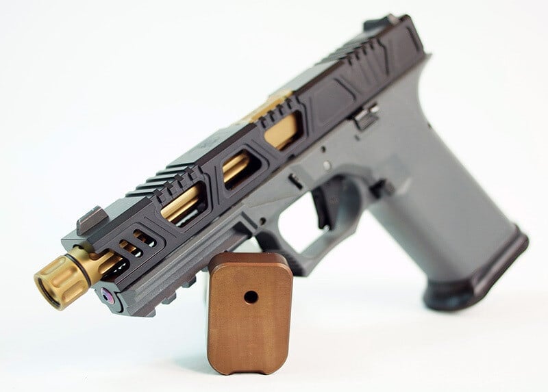 Cyberpunk slide in graphite with gold-lined windows and a gold threaded barrel, on a grey Glock 17 frame with a copper base pad