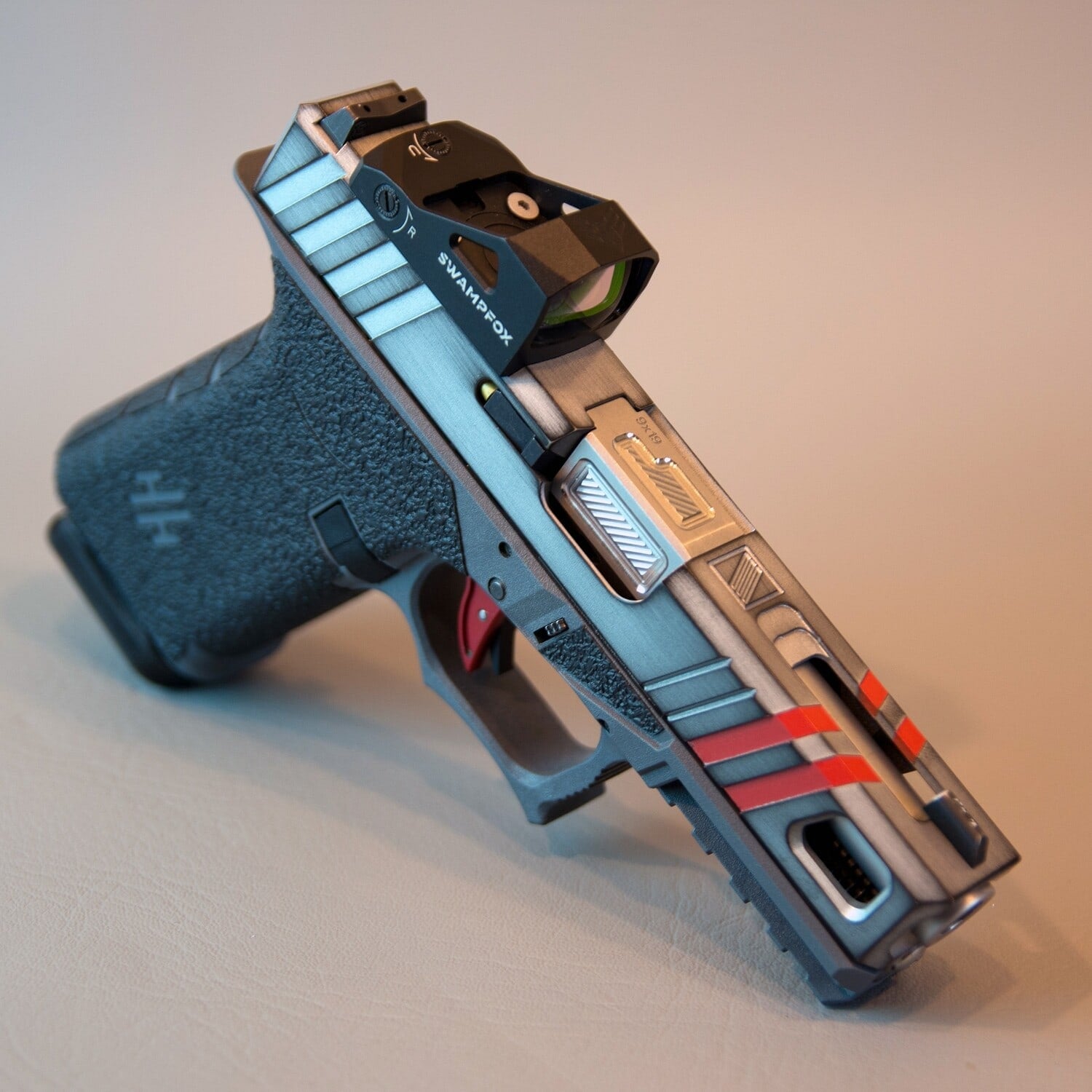 Airman slide in cobalt blue and black with red stripe accents and a red dot optic, on a Glock 19 frame