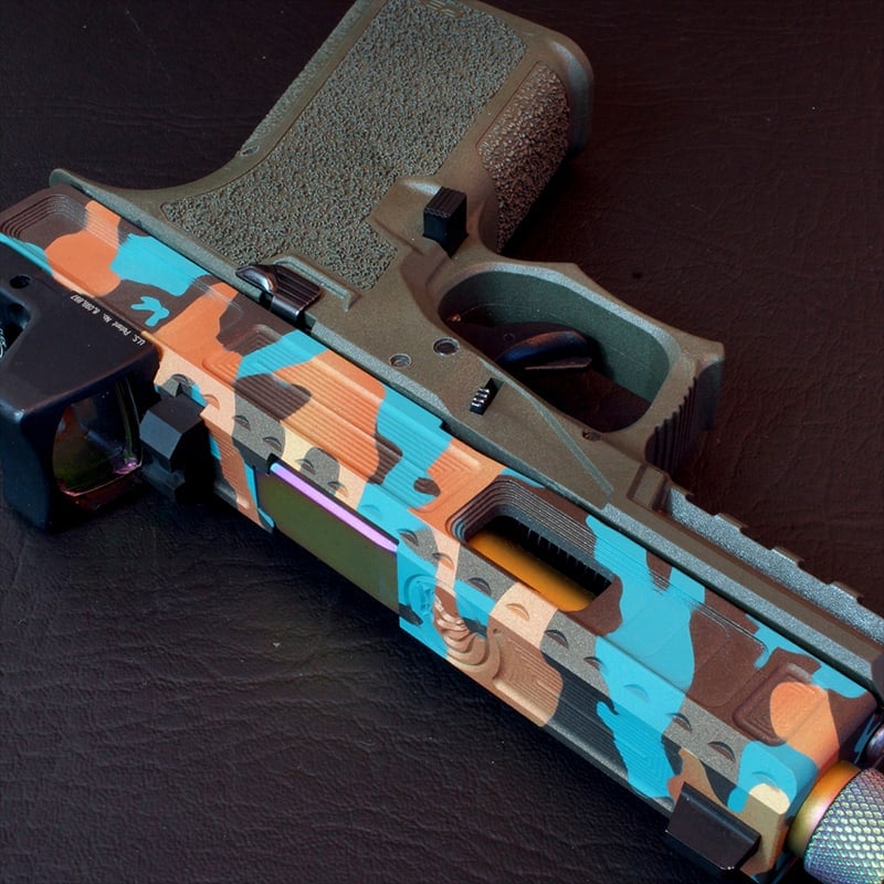 Viper slide in an orange, teal and grey splinter camo Cerakote with a threaded barrel, on a stippled Glock 19 frame