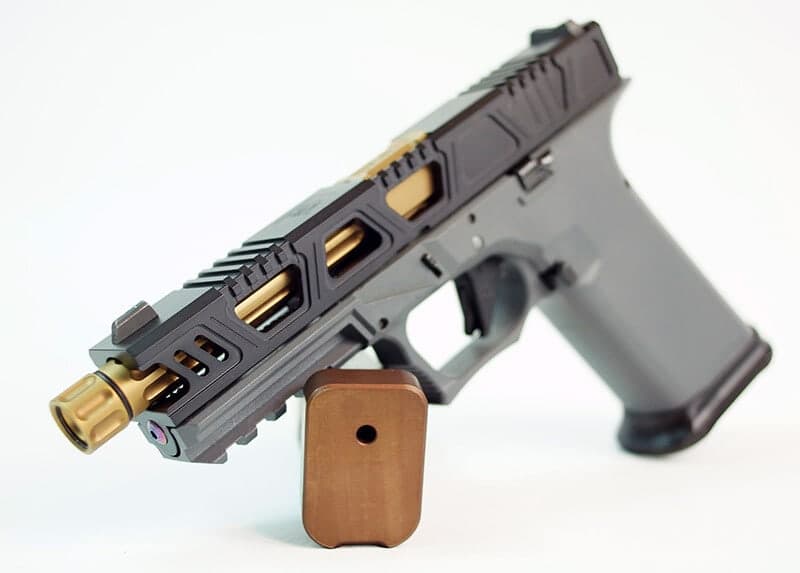 Cyberpunk slide in graphite with gold-lined windows and a gold threaded barrel, on a grey Glock 17 frame with a copper base pad